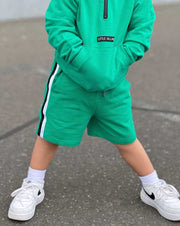 kids green sweat shorts with black white side stripes